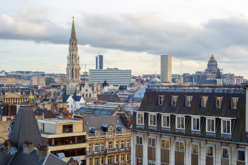 Vue du centre-ville de Bruxelles avec l’Hôtel de Ville et des maisons bruxelloises, illustrant l’article sur l’encadrement des loyers.